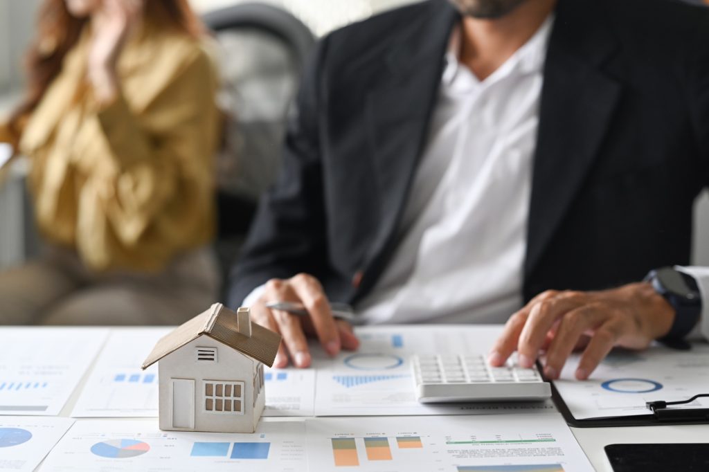Mal investors hand using calculator for calculating loan of finance and planning for real estate.